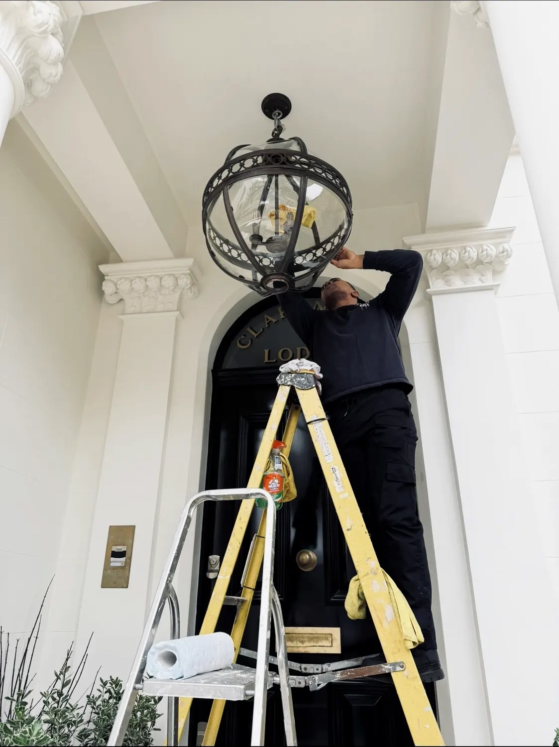 Cleaning a lantern at a prime London property entrance
